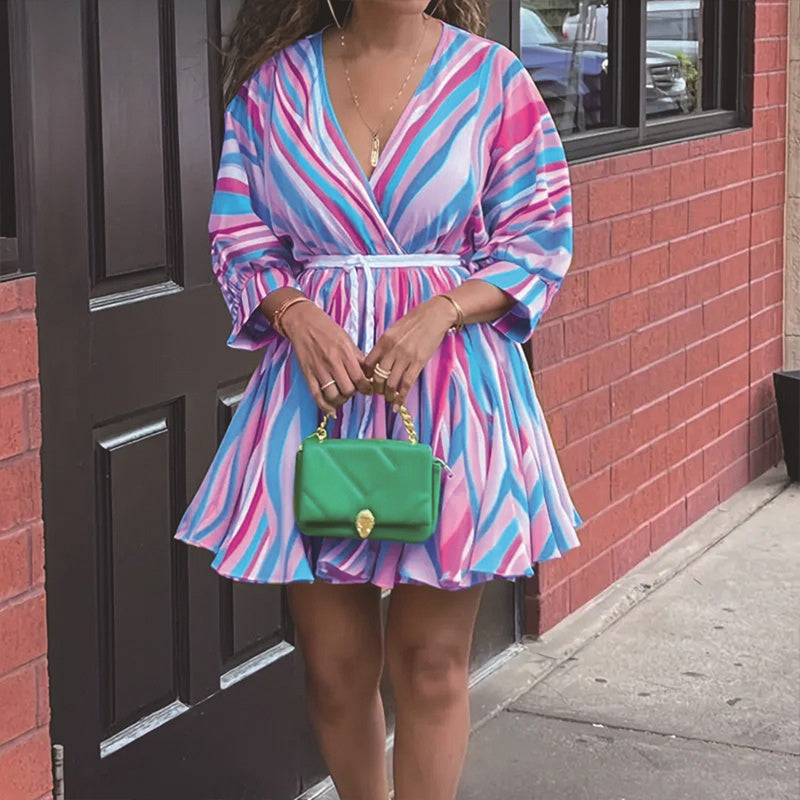 Woman in a colorful dress holding a green handbag 