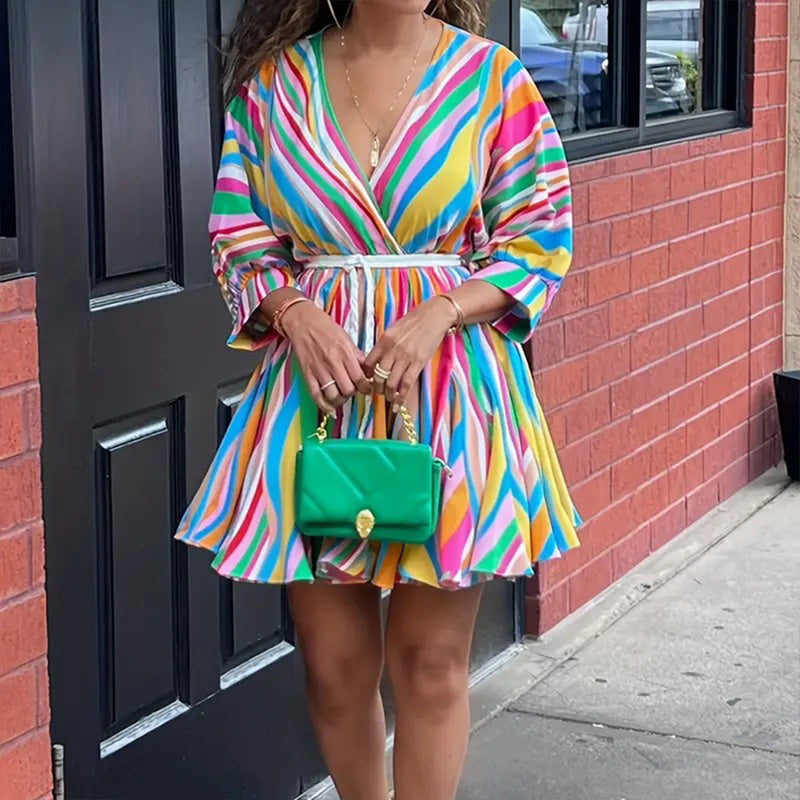 Person wearing a colorful striped dress holding 